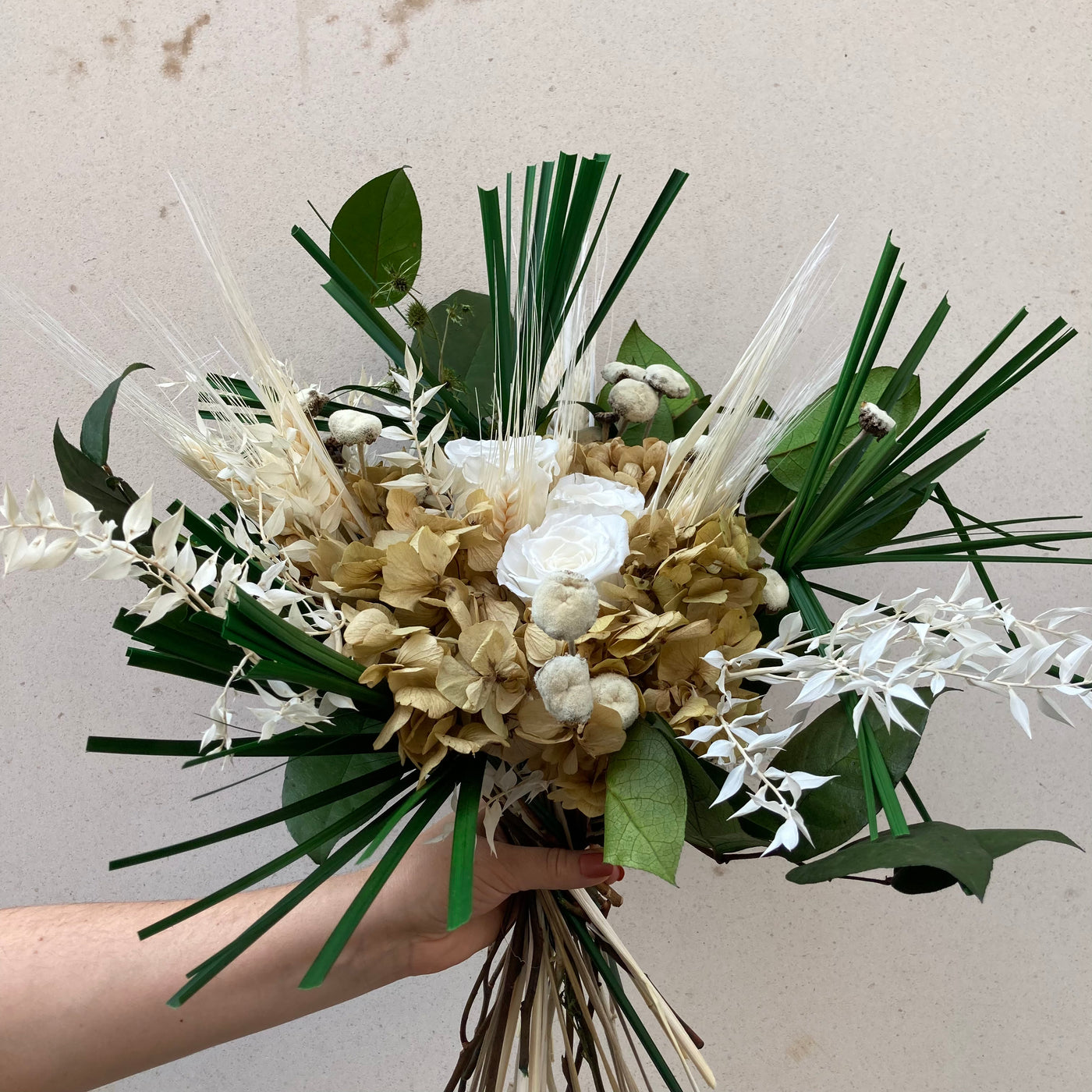 Bouquet de fleurs stabilisées et éternelles beige et vert composé de Salal, Papyrus, Mini chardon, Ruscus, Blé, Pali Pala, Hortensia, Roses blanche. Vu de côté