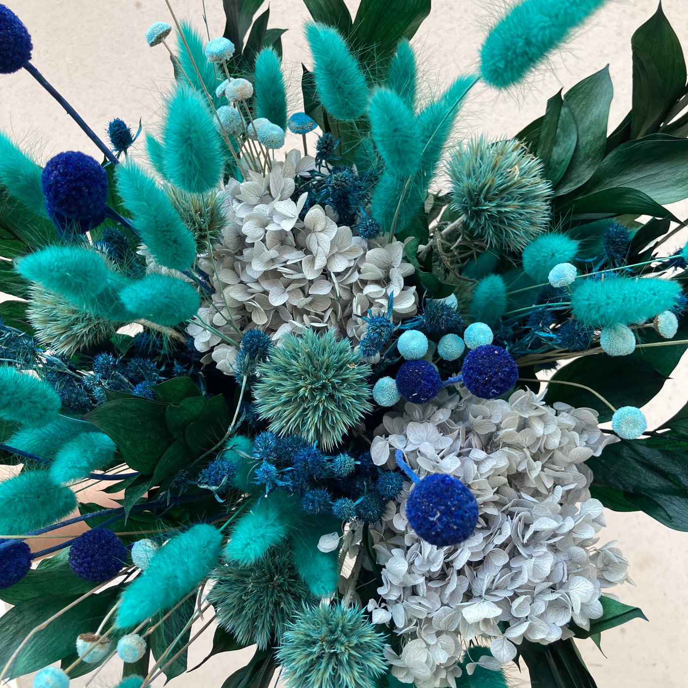 Bouquet en fleurs stabilisées éternelles bleu composé de Lagurus, Hortensia, Ruscus, Chardon, Craspédia, Mini Chardon, Botao. Vu du haut