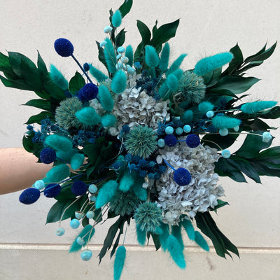 Bouquet en fleurs stabilisées éternelles bleu composé de Lagurus, Hortensia, Ruscus, Chardon, Craspédia, Mini Chardon, Botao. Vu de face