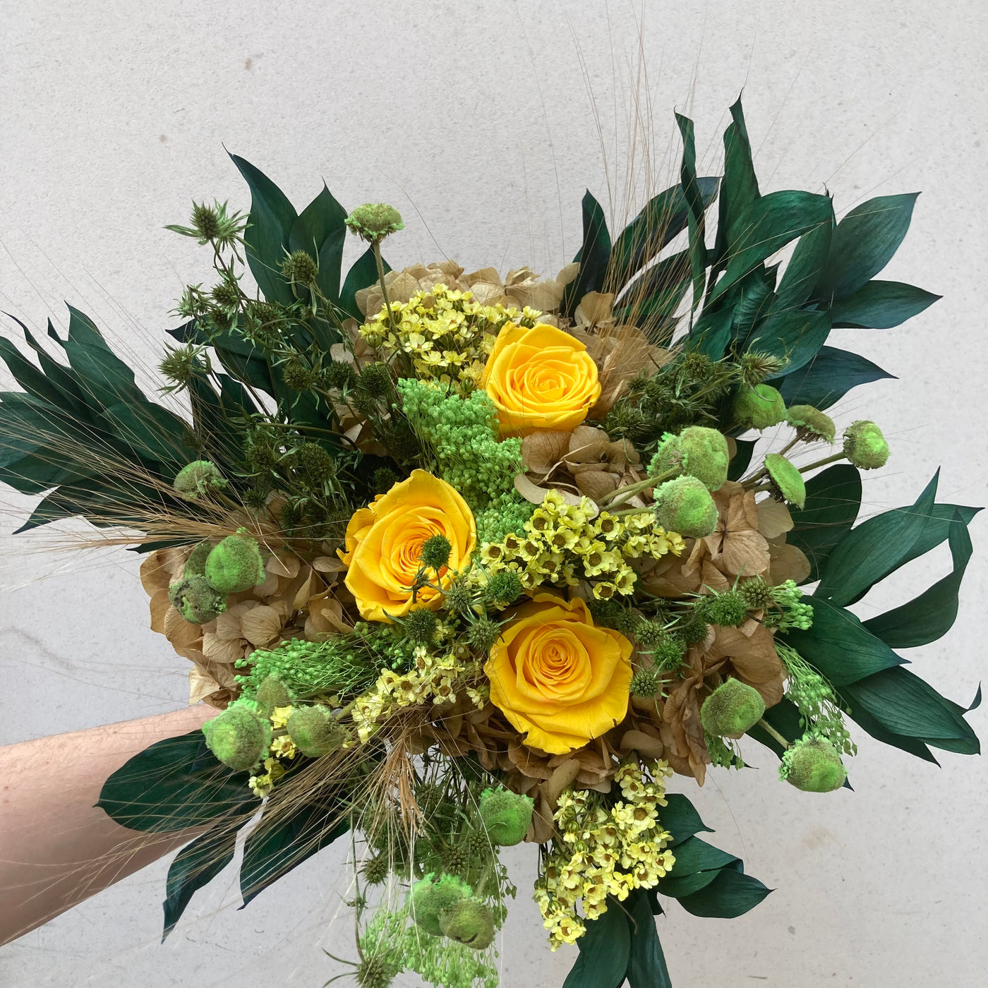 Bouquet en fleurs stabilisées éternelles vert et jaune composé de Roses jaunes, Hortensia, Pali Pala, Ruscus, Ixodia, Mini Chardon. Vu de face