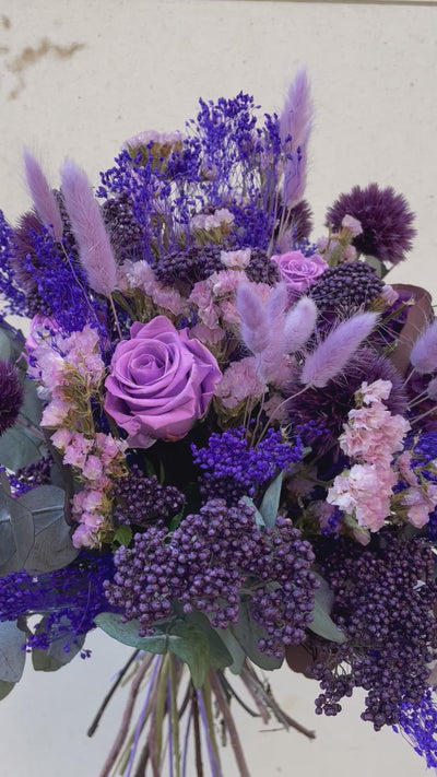 Bouquet de fleurs stabilisées éternelles violet composé de 3 Roses sur grande tige, Gypsophile, Scabiosa, Broom, Chardon Echinops, Lagurus, Statice, Eucalyptus. En mouvement
