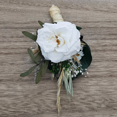 Boutonnière en fleurs stabilisées et éternelles blanche et verte composé de Rose de jardin, Pampa, Mini Gypsophile & Nicoli. Vu du haut