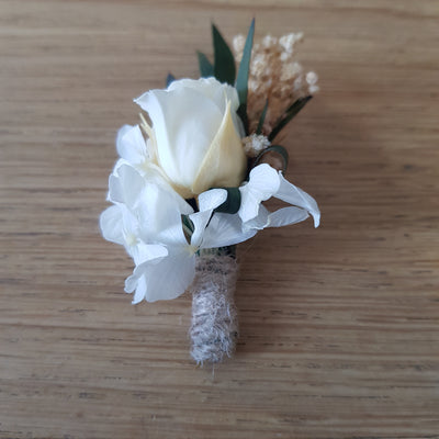 Boutonnière en fleurs stabilisées éternelles blanche composé de Rose, Hortensia, Gypsophile & Nicoly. Vue de côté