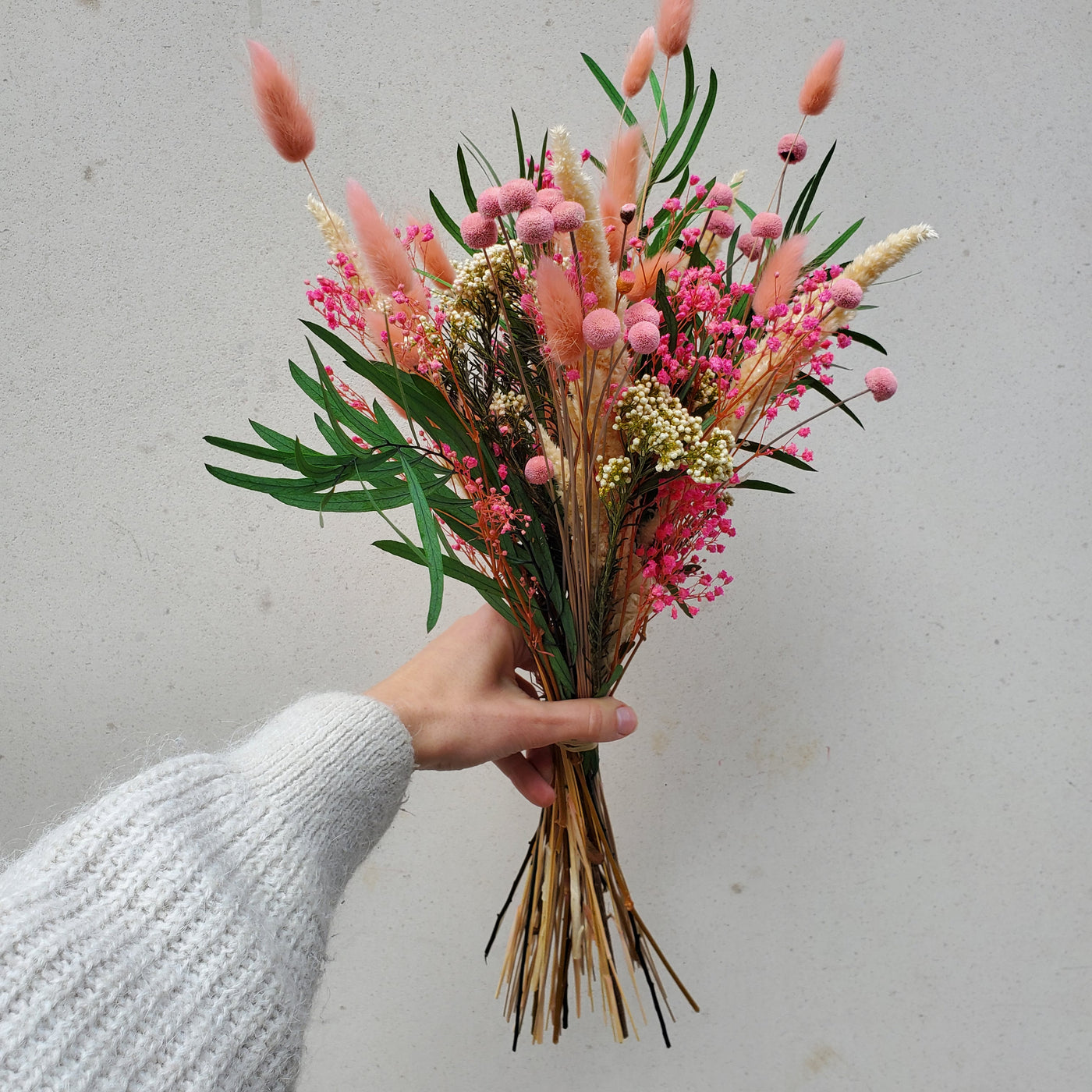 Bouquet de fleurs stabilisées éternelles rose composé de Rose Gyposphile Botao amarante fleur de riz eucalyptus Nicoly. Vue de côté