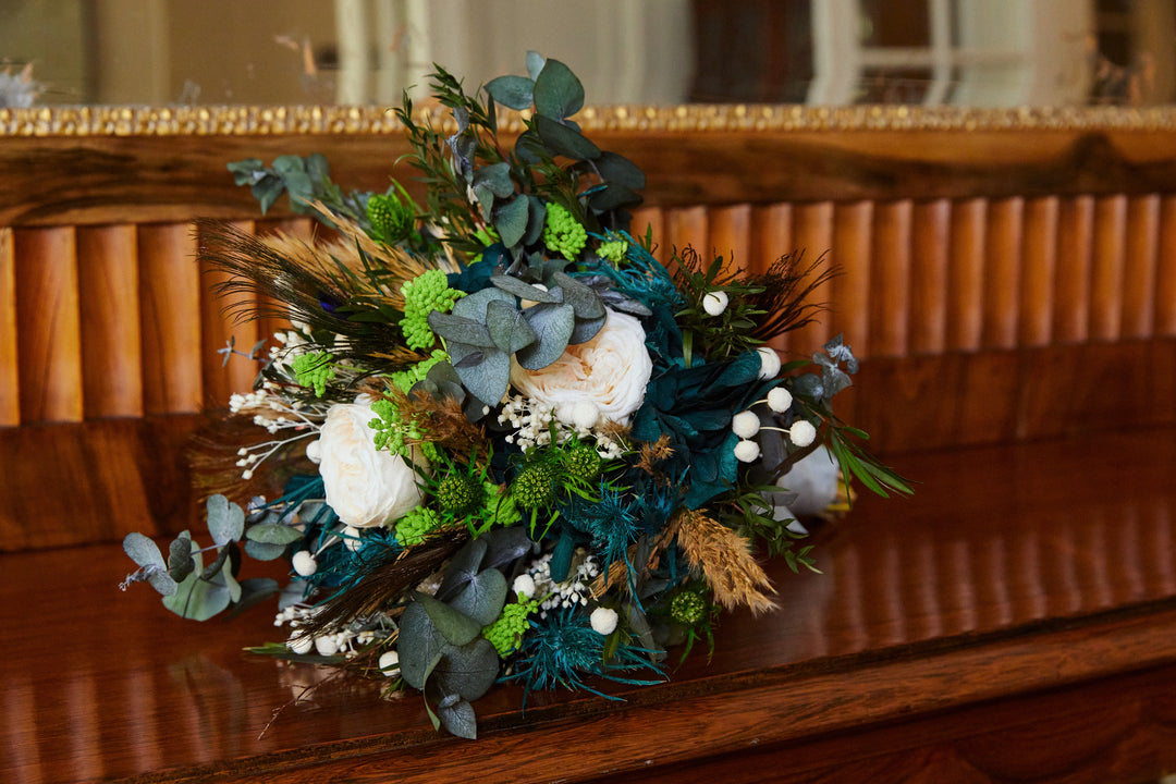 Bouquet de mariée en fleurs stabilisées éternelles bleu et blanc composé de Rose anglaise, Hortensia, Achilée, Pampa, Botao, Broom, Erygium, Lepto, Cinerea & Plume de Paon. Vu avant