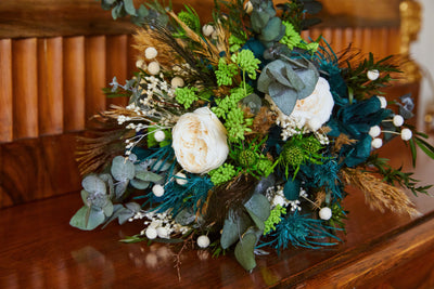 Bouquet de mariée en fleurs stabilisées éternelles bleu et blanc composé de Rose anglaise, Hortensia, Achilée, Pampa, Botao, Broom, Erygium, Lepto, Cinerea & Plume de Paon. Vu rapproché