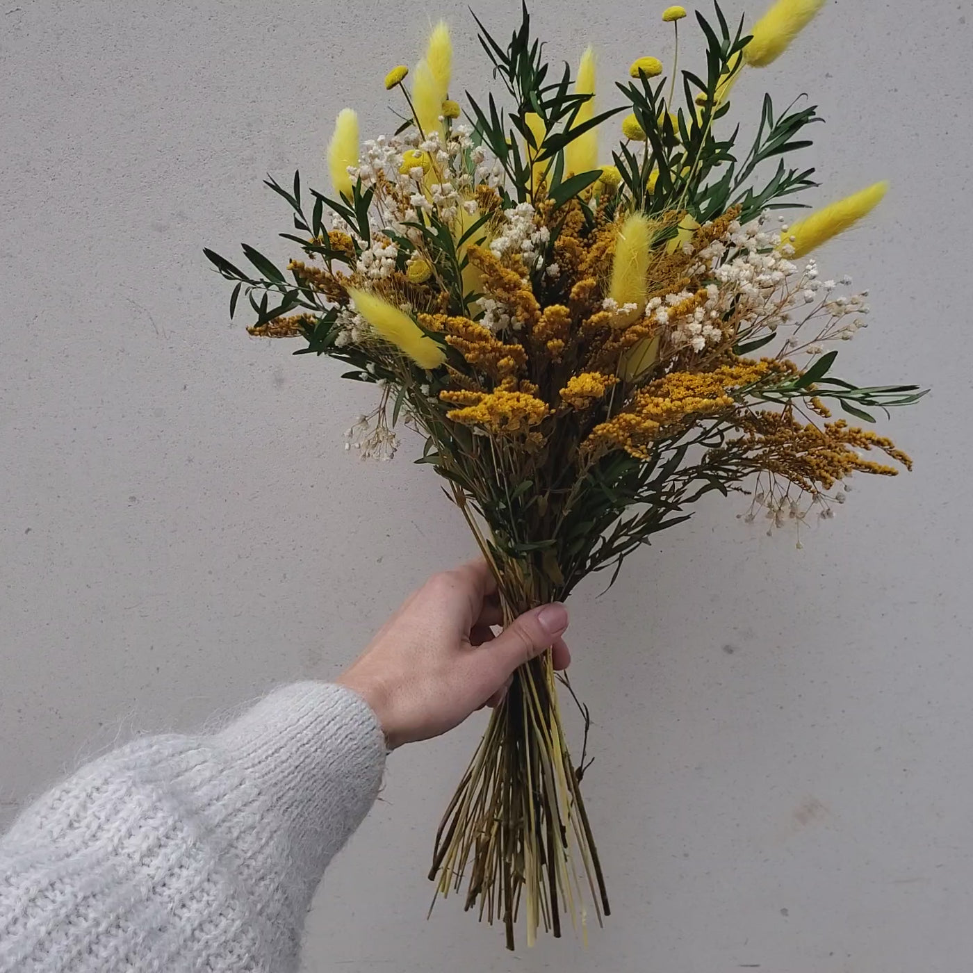 Bouquet de fleurs stabilisées éternelles jaune composé de gypsophile solidago lagurus botao lepto longifolia. En mouvement