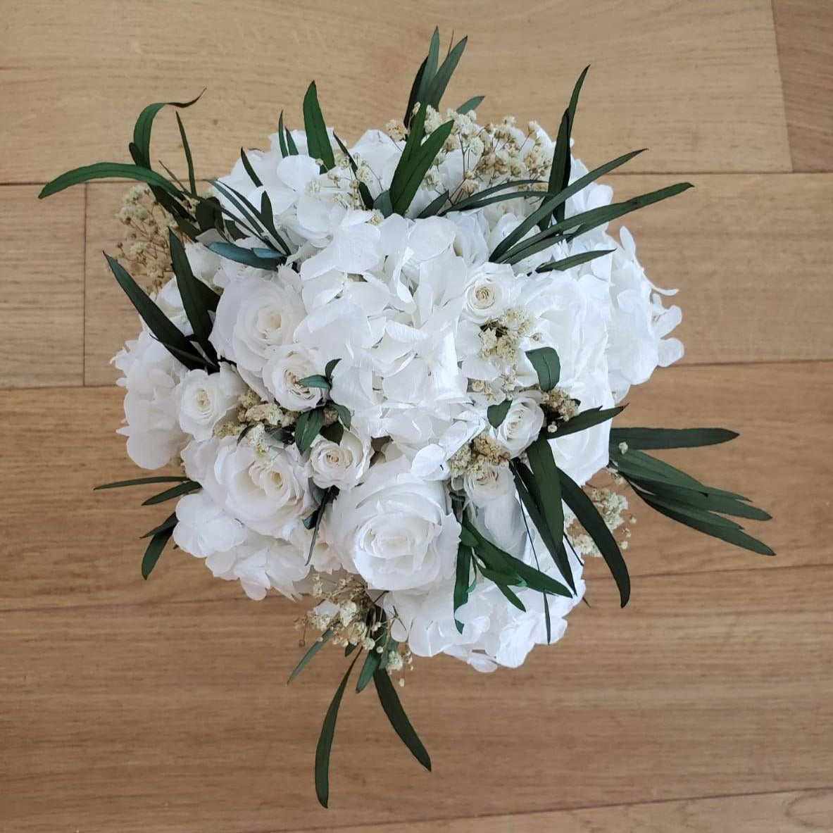 Bouquet de mariée en fleurs stabilisées éternelles blanc composé de Roses, Hortensia, Gypsophile & eucalyptus Nicoli. Vu de face