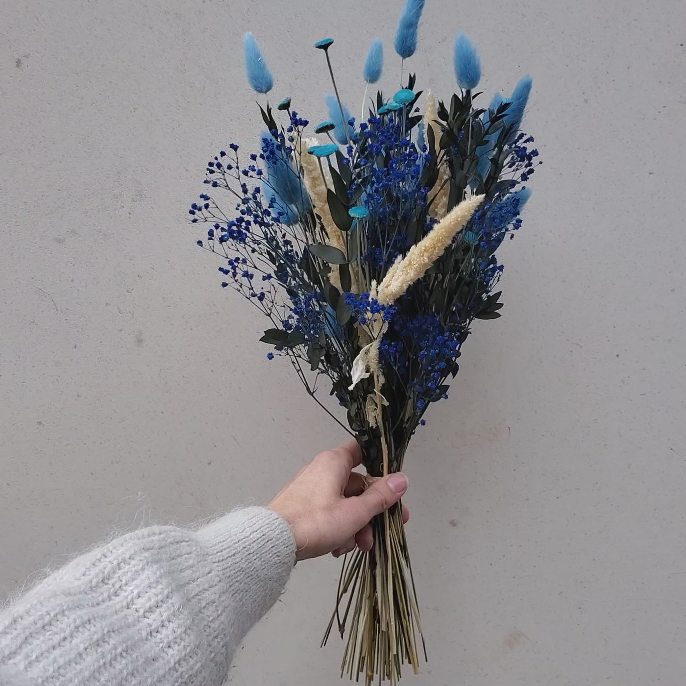 Bouquet de fleurs stabilisées éternelles bleu composé d'amarante gypsophile lagurus botao eucalyptus parvifolia. En mouvement
