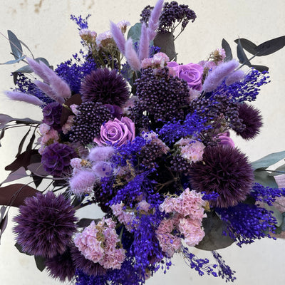 Bouquet de fleurs stabilisées éternelles violet composé de 3 Roses sur grande tige, Gypsophile, Scabiosa, Broom, Chardon Echinops, Lagurus, Statice, Eucalyptus. Vue de face