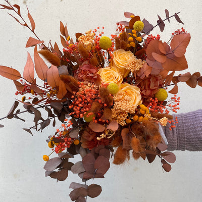 Bouquet de fleurs stabilisées éternelles orange composé de 3 Roses, Broom, Lagurus, Craspedia, Achillée, Botao, Eucalyptus Stuartiana. Vue de face