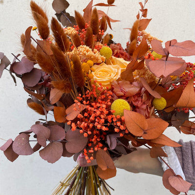 Bouquet de fleurs stabilisées éternelles orange composé de 3 Roses, Broom, Lagurus, Craspedia, Achillée, Botao, Eucalyptus Stuartiana. Vue de côté